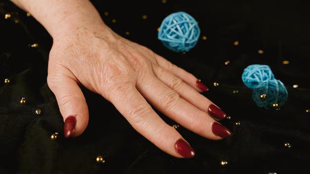 Imagem de uma mão de uma mulher madura com as unhas pintadas