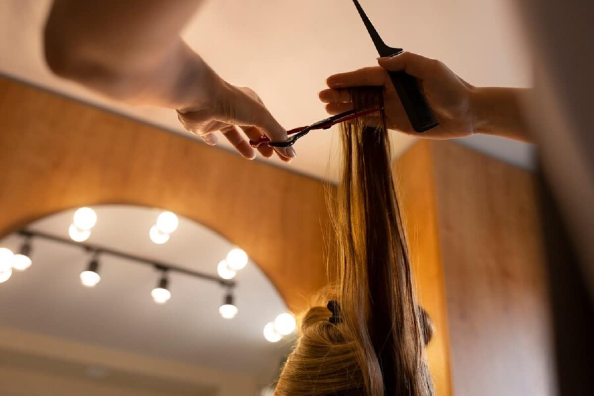 uma cliente a cortar o cabelo no cabeleireiro