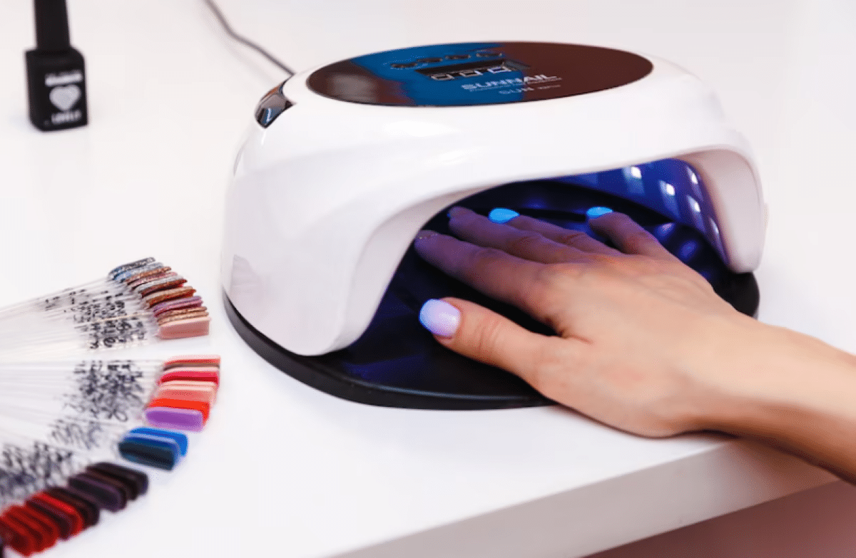 Imagem de uma mulher fazendo as unhas em gel