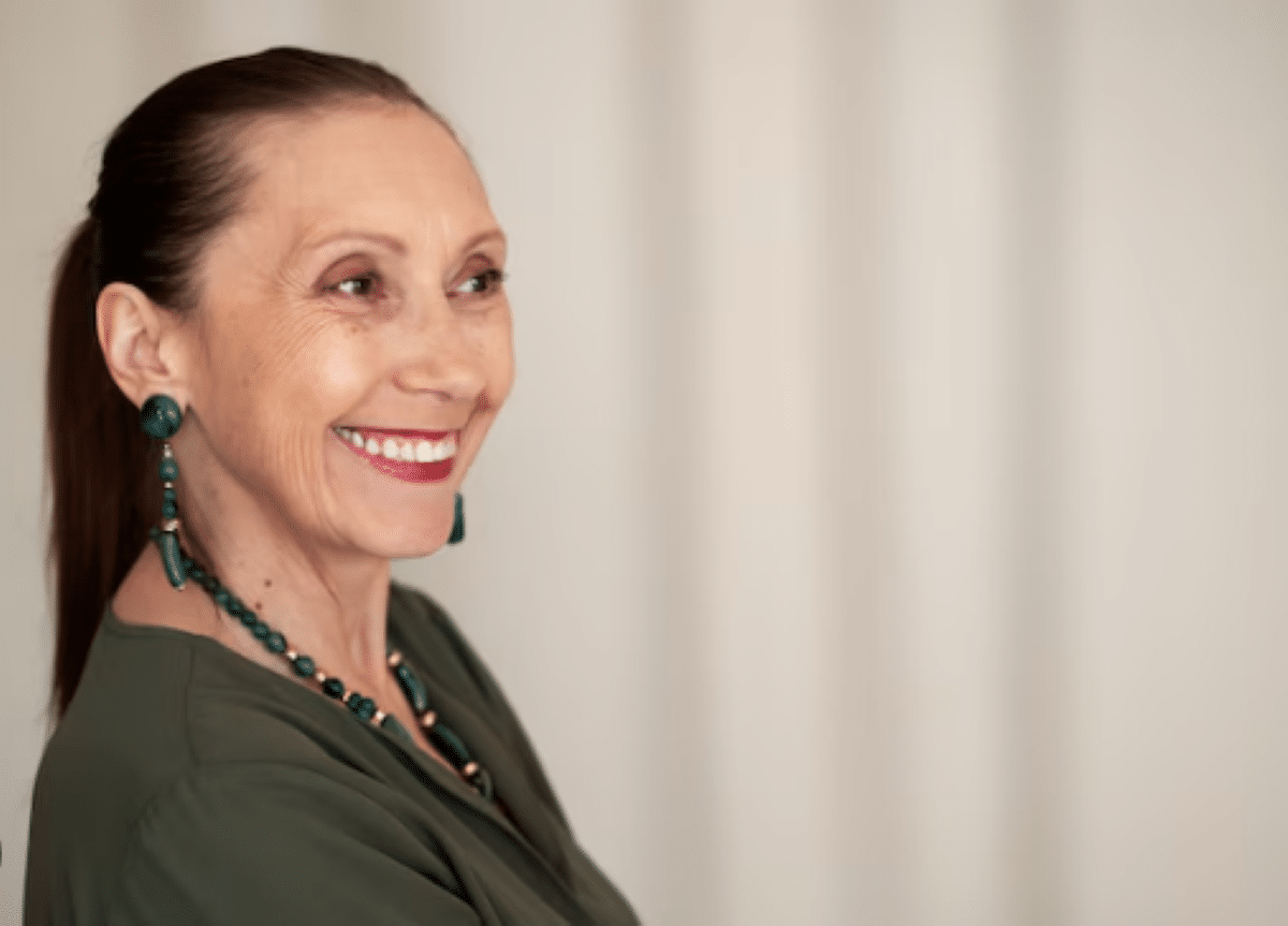 Mulher madura sorrindo com cabelos saudáveis e bem cuidados.