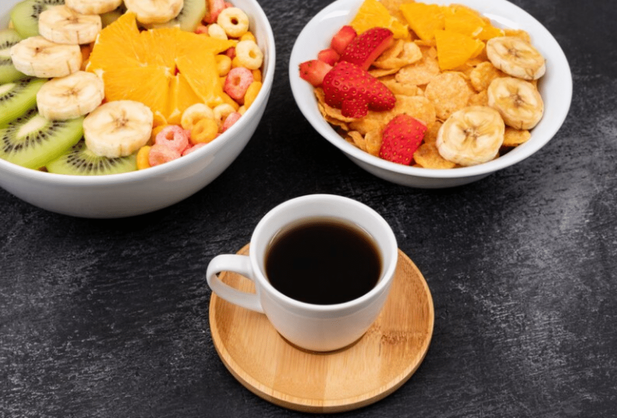 Prato de café da manhã com frutas frescas, cereais e café.