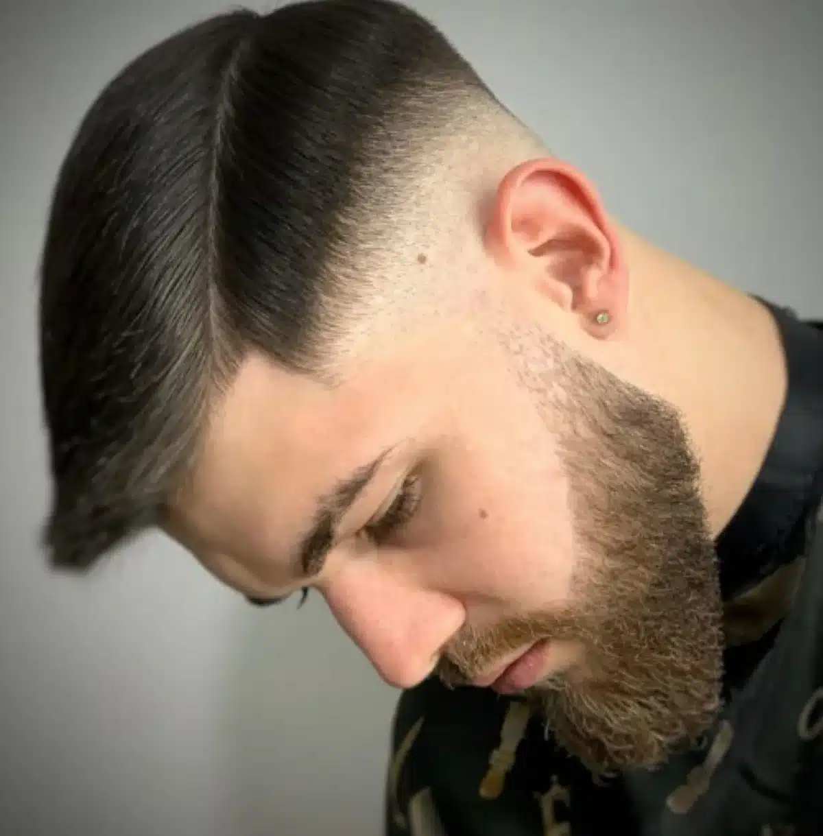 Homem com cabelo dividido ao meio e fade nas laterais