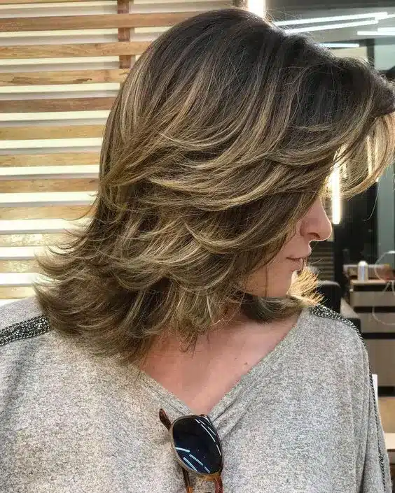 Cabelo com camadas frontais volumosas, criando um visual moderno e elegante.