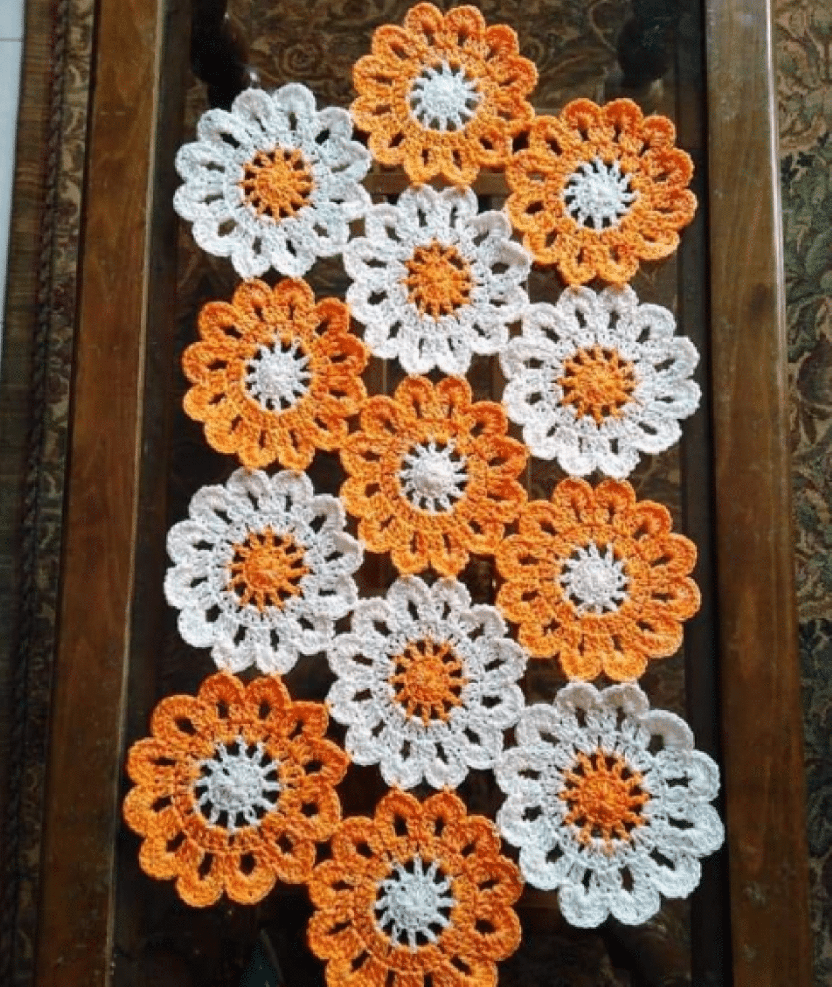 Caminho de mesa em crochê com flores coloridas, representando um design luxuoso e sofisticado.