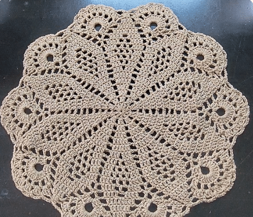 Caminho de mesa redondo em crochê com detalhes delicados.