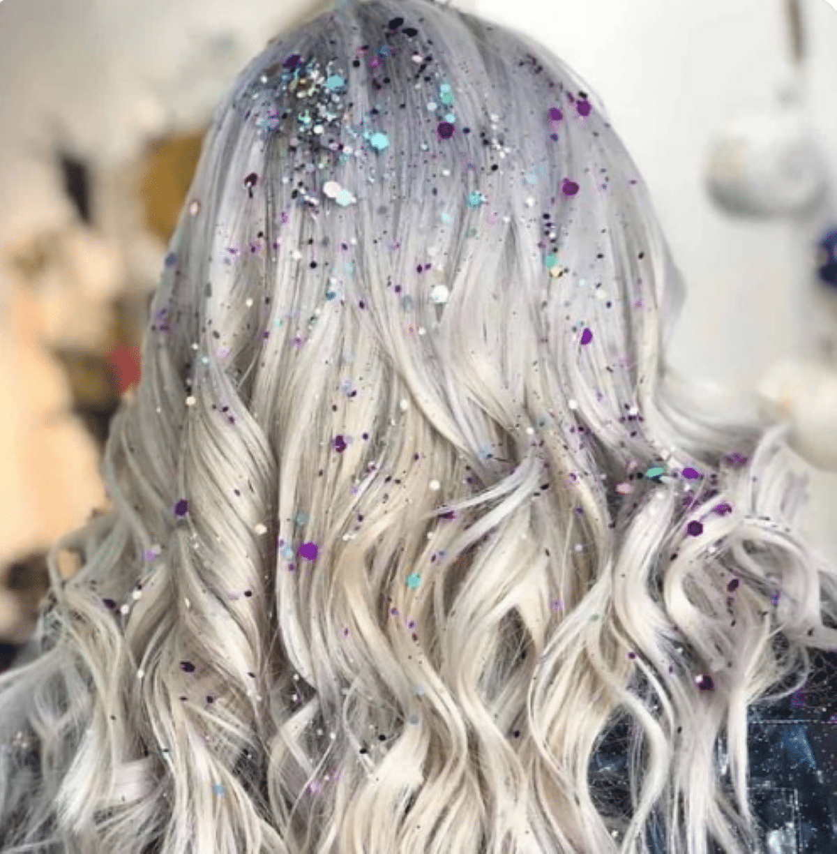 Cabelo loiro ondulado com brilhos coloridos, ideal para um penteado ousado no Carnaval.