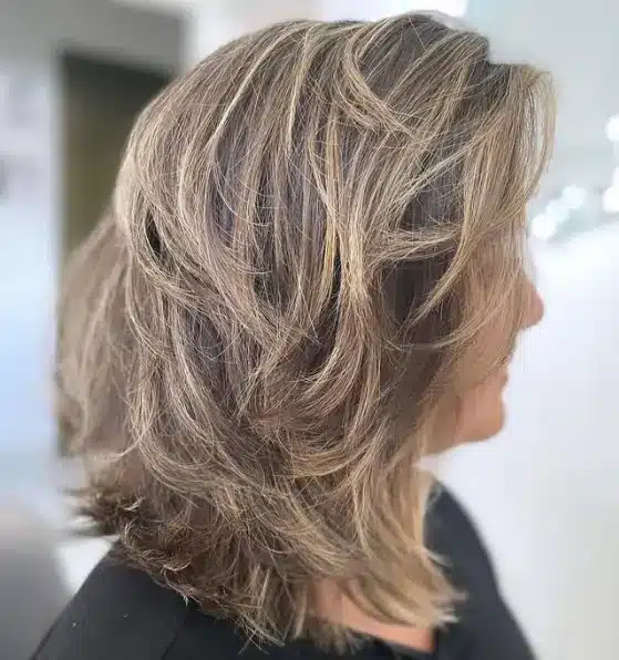 Corte de cabelo desfiado sutil com movimento e textura natural.