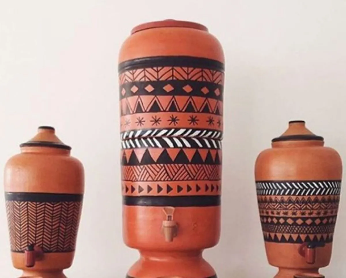 Filtros de barro com pintura artesanal em tons terrosos.