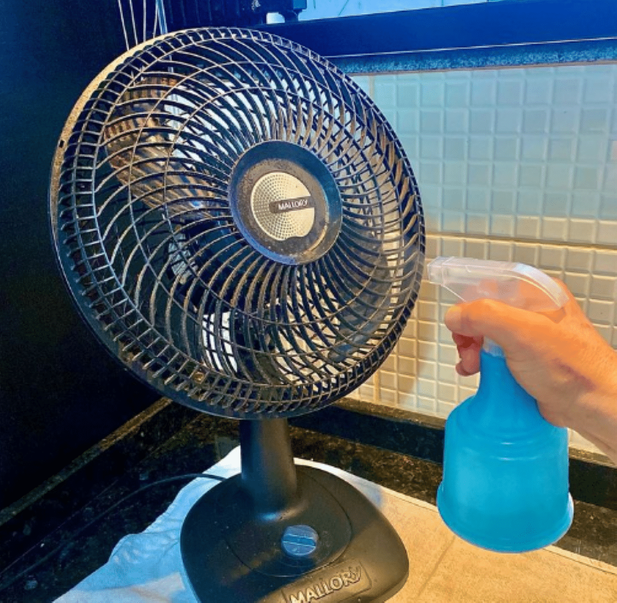Pessoa usando um saco plástico para limpar a parte traseira de um ventilador