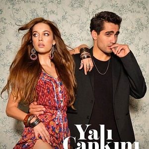 Casal de protagonistas da novela turca 'O Canto do Pássaro' em um cenário romântico