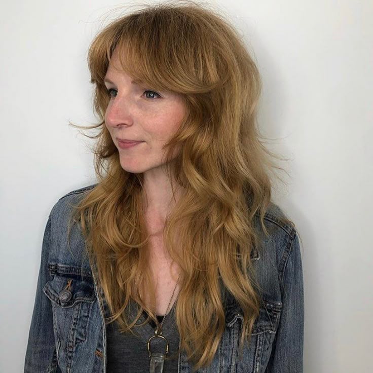 Mulher jovem com corte soft shag em cabelo loiro ondulado