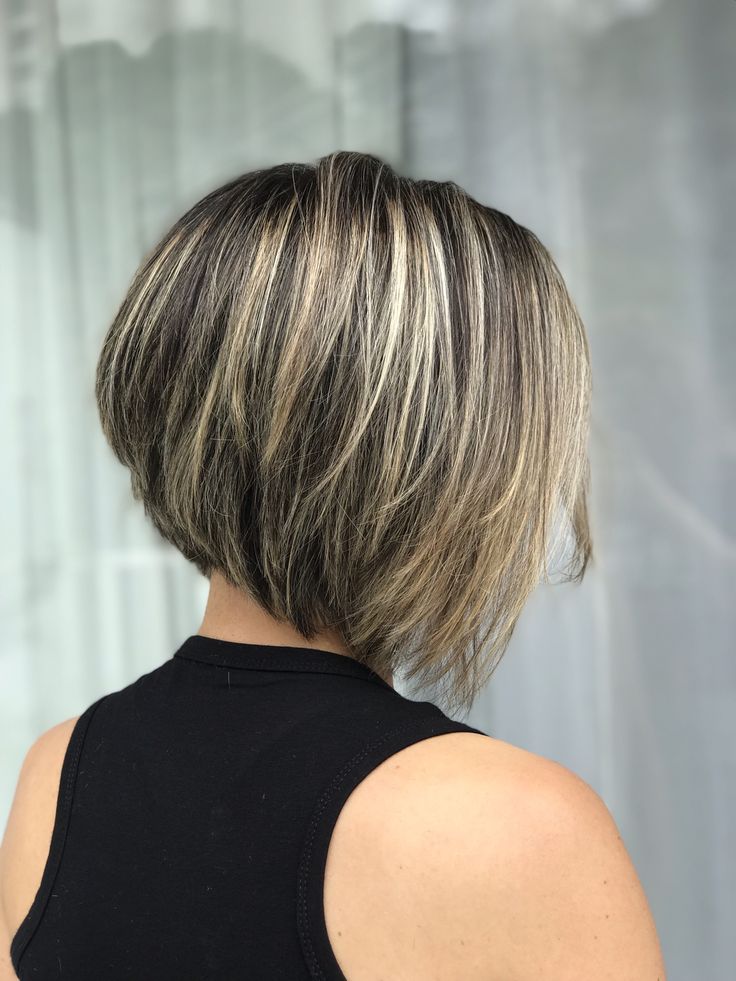 Bob desfiado assimétrico com luzes, criando um visual moderno e cheio de movimento.