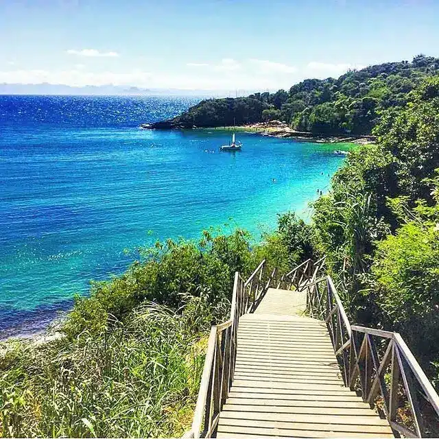 Cenário paradisíaco de Búzios Escada de madeira descendo até o mar cristalino de Búzios, com uma vista deslumbrante.