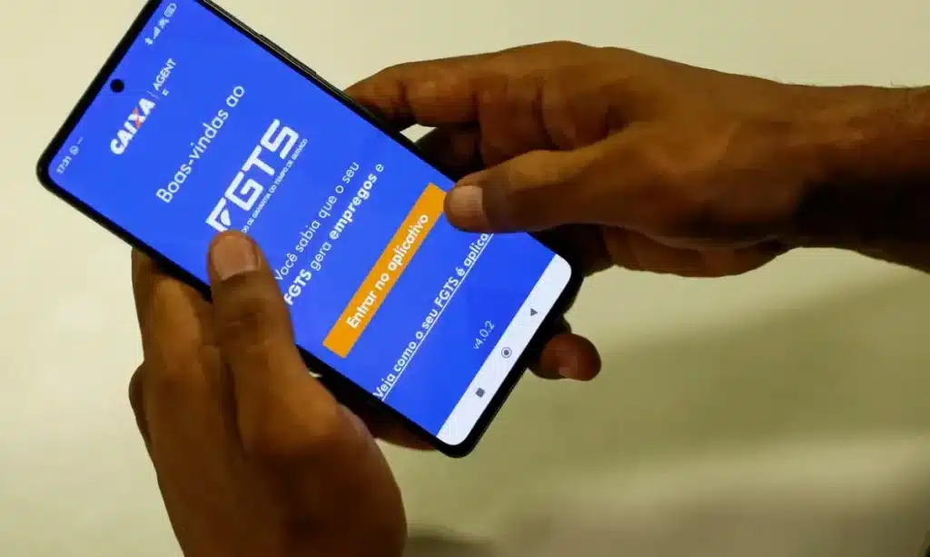 Pessoa acessando o aplicativo do FGTS no celular para consulta de saldo e benefícios.
