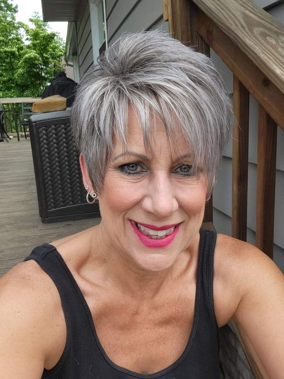 Mulher sorridente com corte pixie alongado em cabelo grisalho