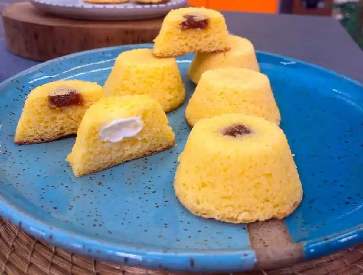 Mini bolos de fubá escaldado com recheio de goiabada e requeijão servidos em um prato azul.