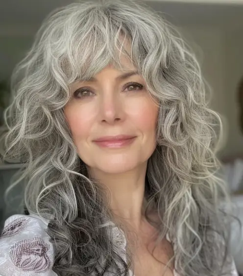 "Mulher com cabelo grisalho e ondulado, usando corte shaggy, um estilo moderno e volumoso."