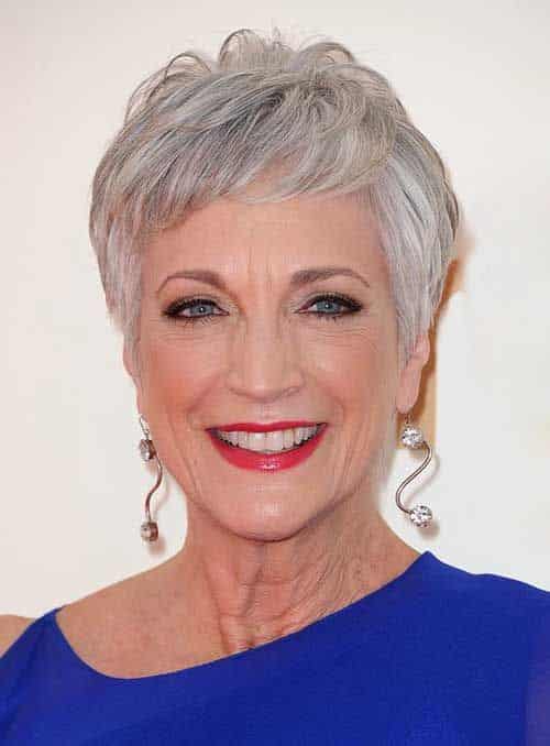 Mulher madura com corte de cabelo pixie cut prateado, sorrindo com elegância.