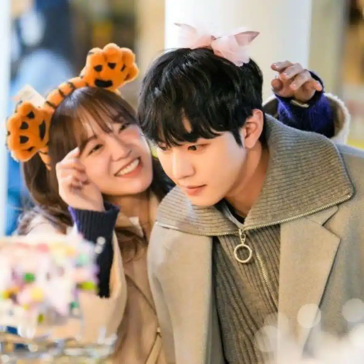 Casal de dorama se divertindo com acessórios engraçados e expressões alegres.