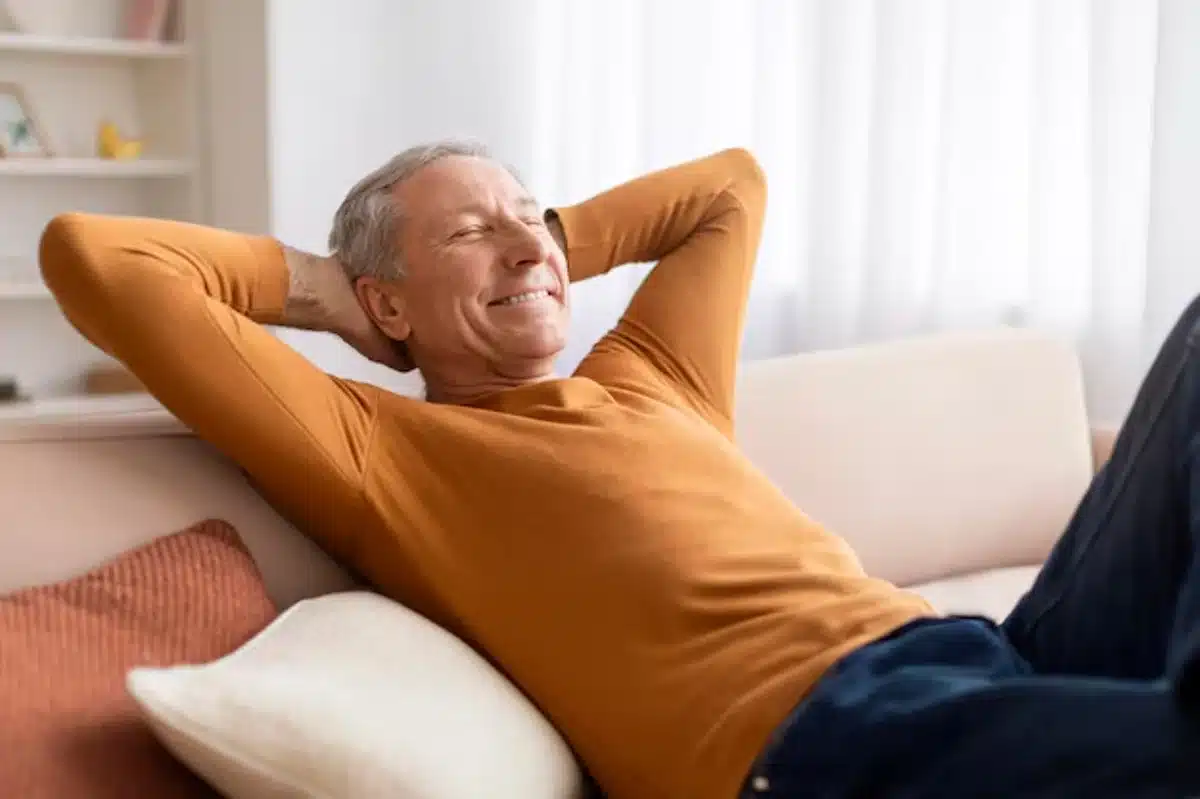 Homem relaxando no sofá durante os feriados de abril de 2025, aproveitando momentos de descanso e lazer.