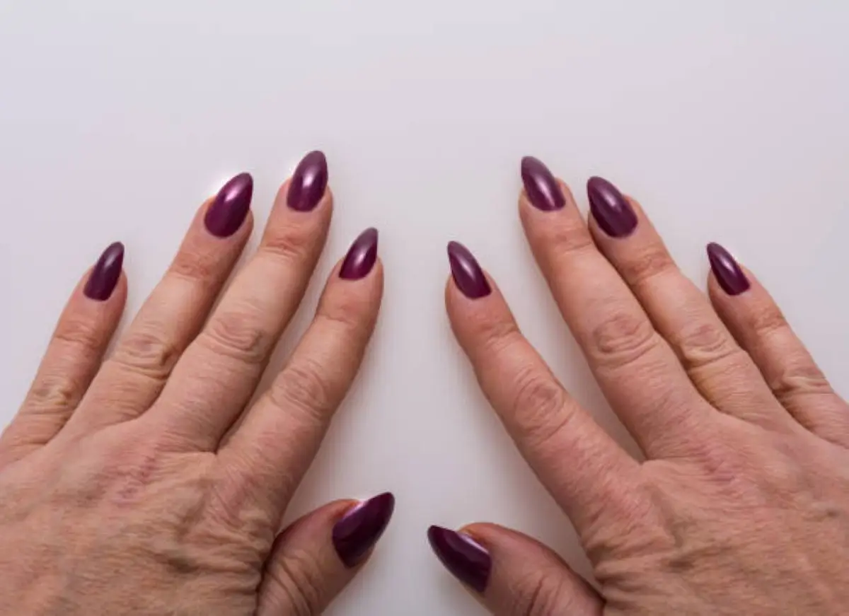 Unhas de gel e alongamento em mãos de idosa, ilustrando cuidados estéticos para a terceira idade