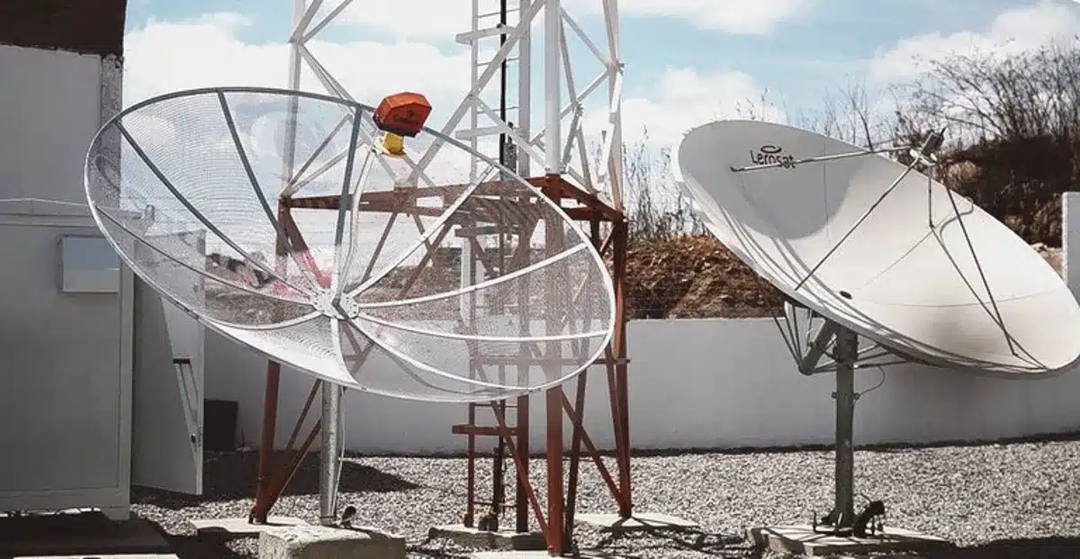 Imagem de antenas parabólicas digitais instaladas em um local aberto, representando a modernização do sinal de TV.
