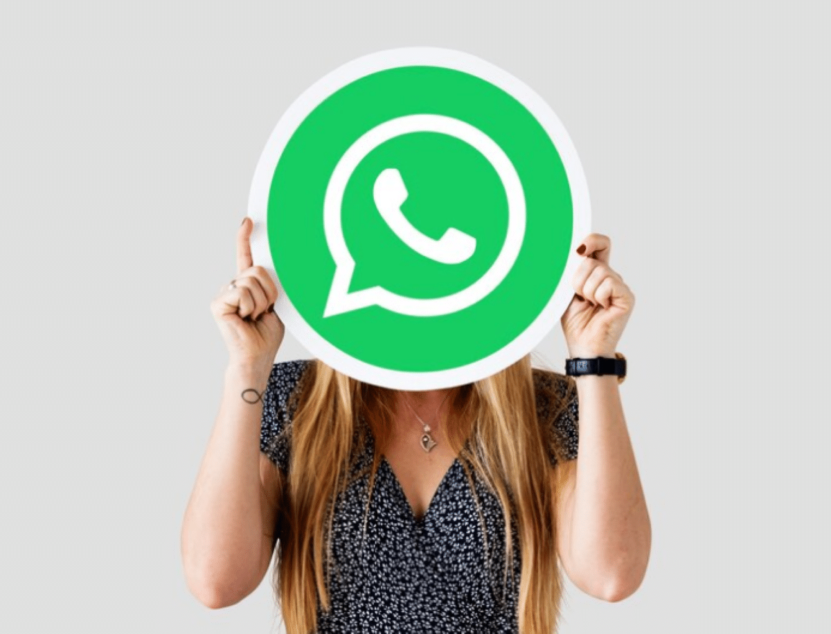 Pessoa segurando um grande ícone do WhatsApp, representando as melhores legendas para fotos no WhatsApp.