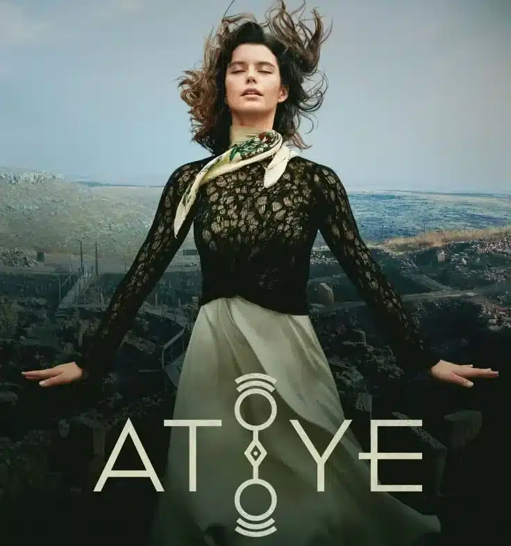 Imagem promocional da série 'Atiye' (O Segredo do Templo), mostrando uma mulher em um cenário aberto, com os cabelos ao vento, vestindo um vestido longo e elegante, em meio a uma paisagem misteriosa.
