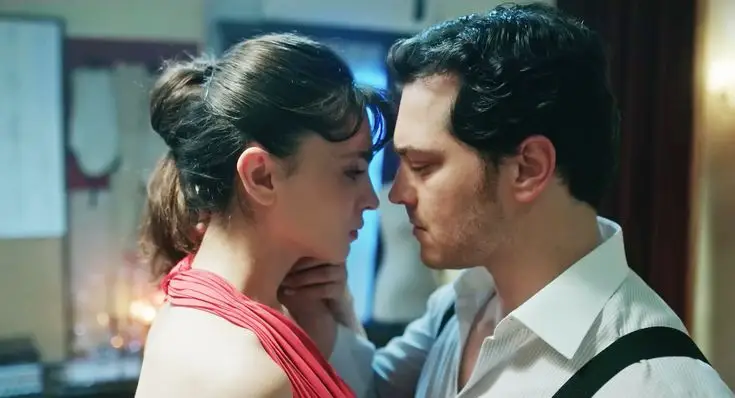 Cena de Peyami e Esvet, personagens da novela turca, em um momento íntimo e romântico, abordando o amor, segredos de família e moda.