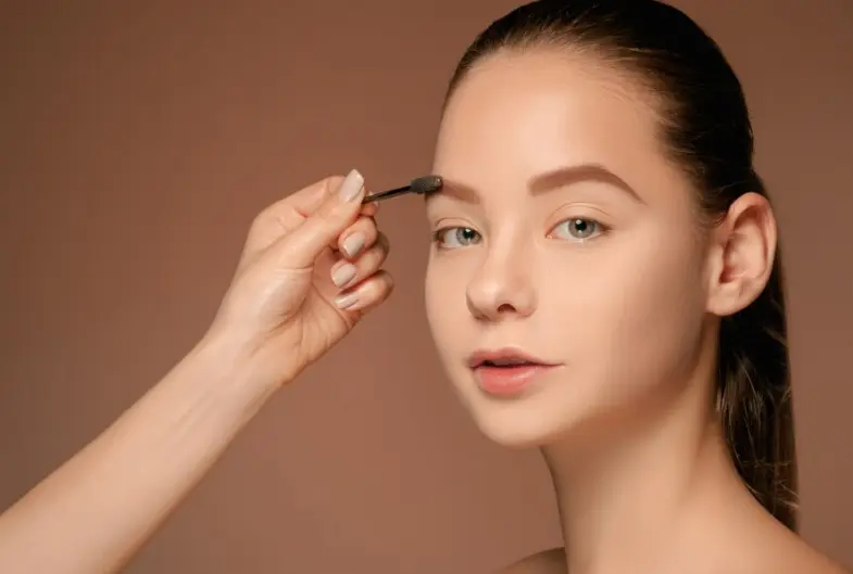 Mulher aplicando produto nas sobrancelhas, mostrando como manter a saúde dos folículos.