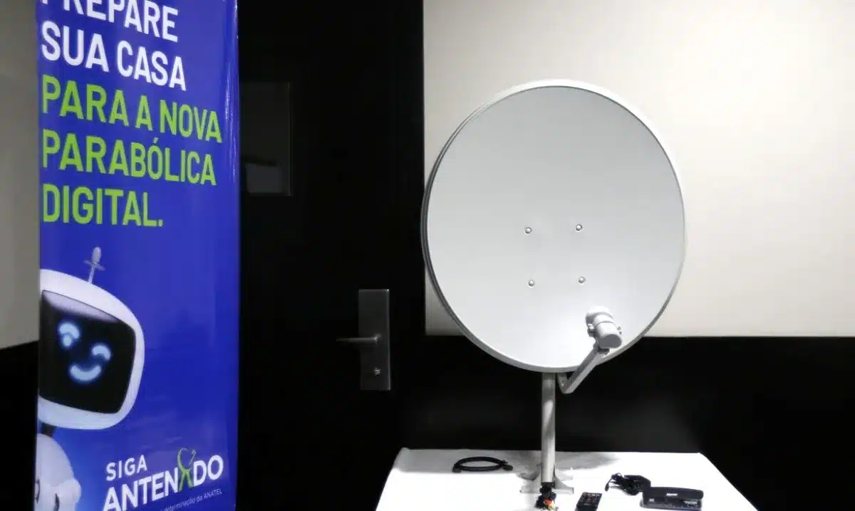 Antena parabólica digital com banner informativo sobre a troca gratuita, incentivando a substituição para garantir o acesso à TV aberta.