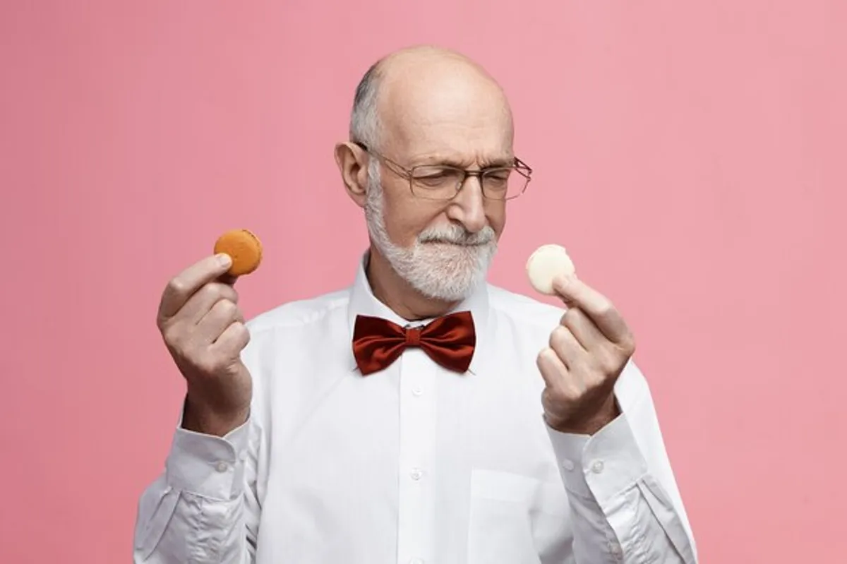 Idoso ponderando sobre alternativas saudáveis de alimentos doces, como biscoitos caseiros.