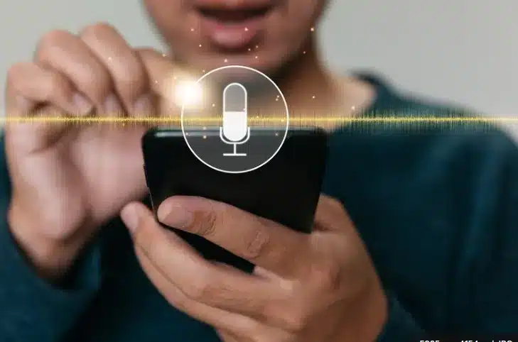 Pessoa ativando o microfone do celular para usar comando de voz.