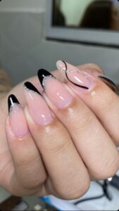 Unhas alongadas em fibra de vidro com esmaltação francesa preta e detalhes com glitter prateado.