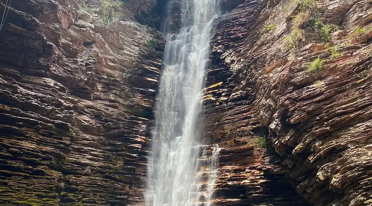 Cachoeira do Roncador, em Mucugê, com sua imponente queda d'água descendo pelas paredes de rochas coloridas.