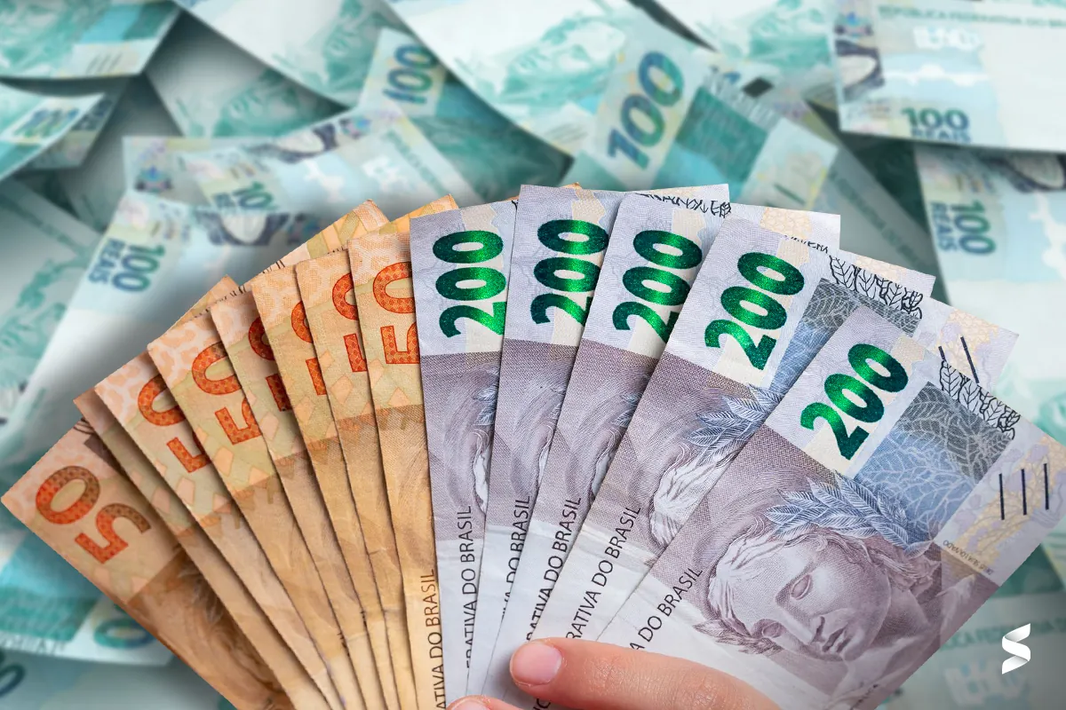 Cédulas de R$ 50, R$ 100 e R$ 200, representando o cálculo do 13º salário do INSS.
