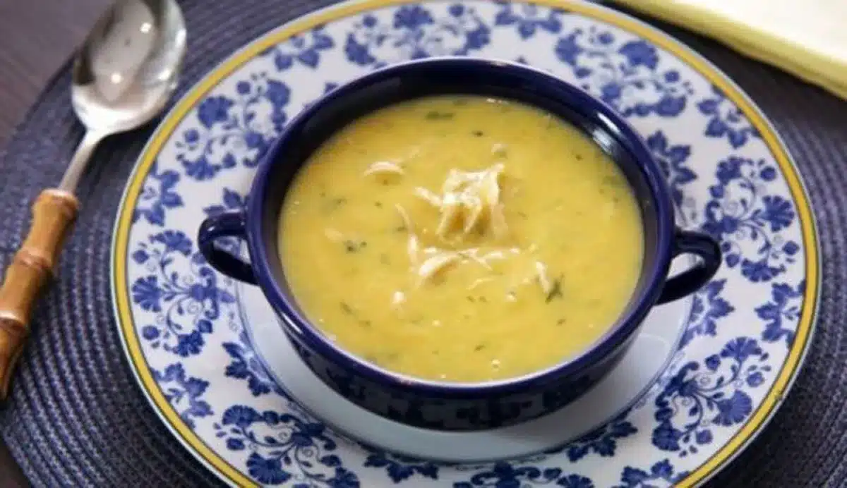 Canja cremosa de frango servida em tigela azul com detalhes florais