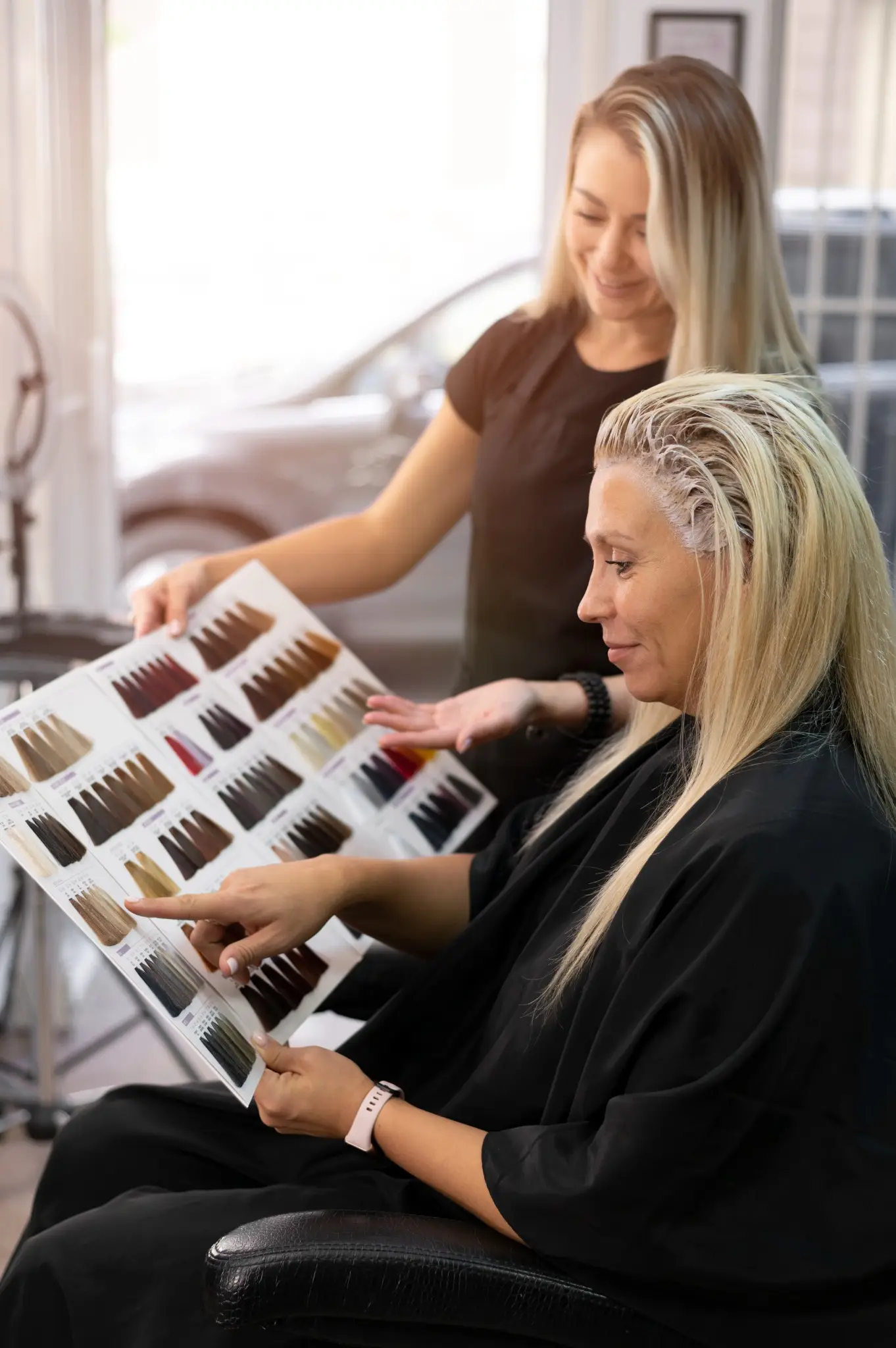 Cliente no salão escolhendo a cor ideal para coloração suave de cabelo, com a ajuda de uma profissional.