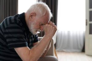 Homem idoso demonstrando sinais de confusão, um dos sintomas precoces do Alzheimer, com foco nas dificuldades cognitivas.