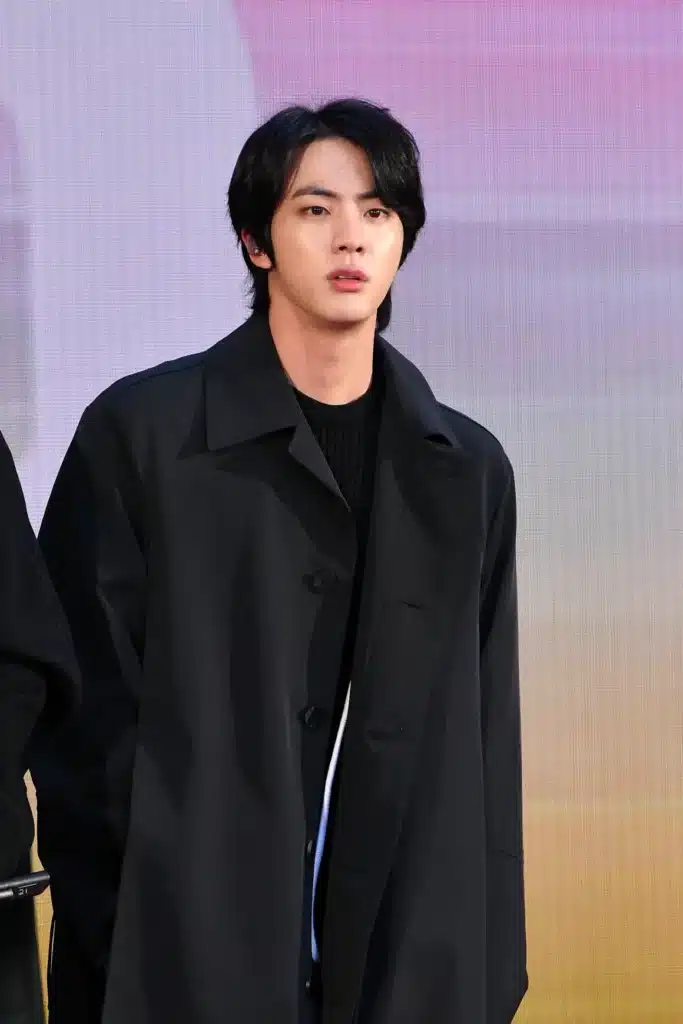 Jin do BTS com corte de cabelo estilo lobo, com camadas longas e cauda longa