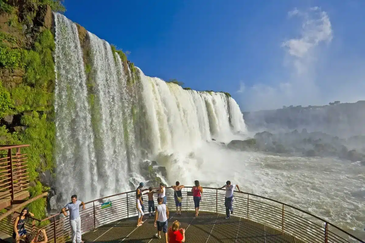 Visitantes aproveitando a vista das Cataratas do Iguaçu em uma plataforma de observação.