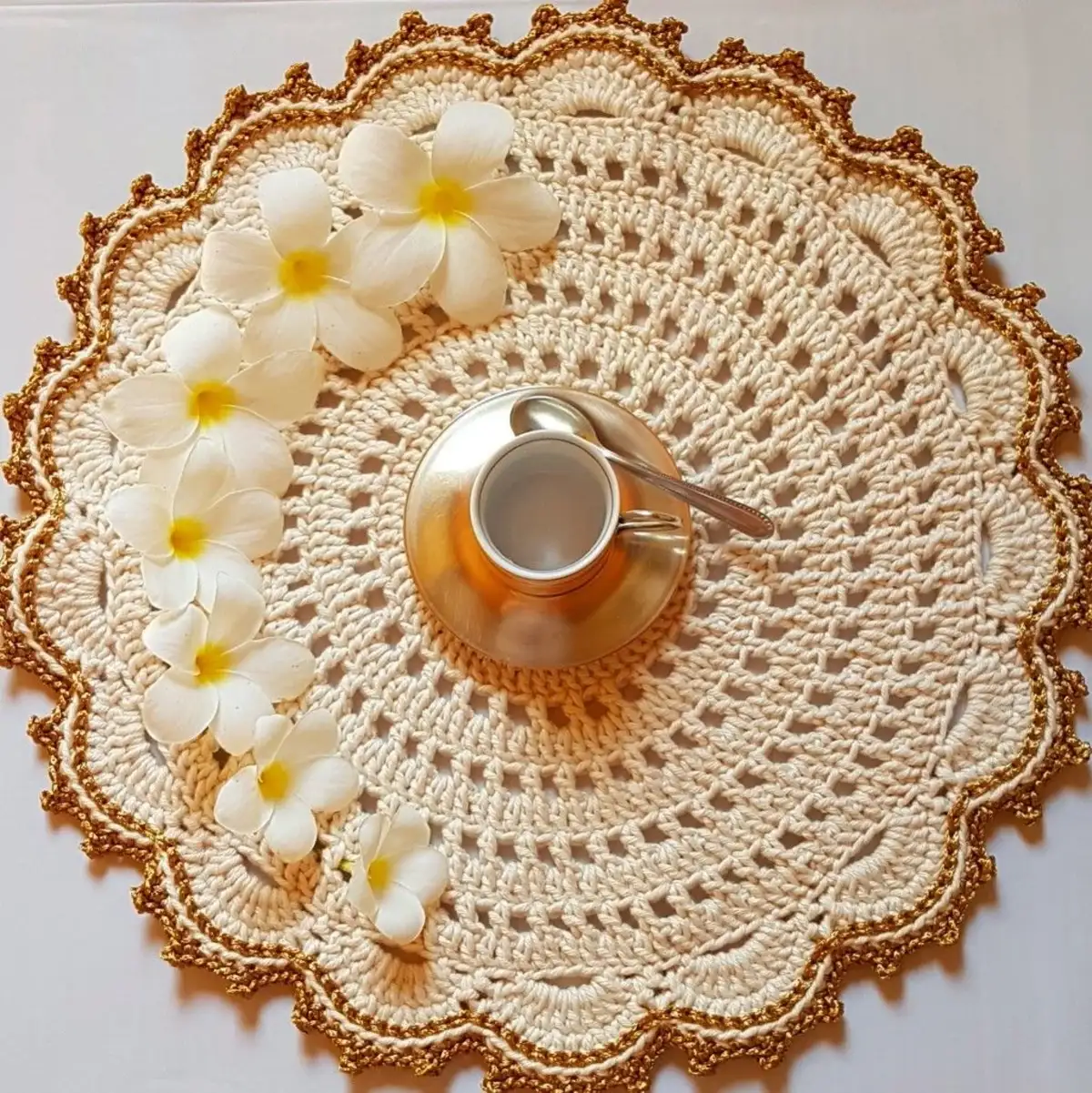Sousplat de crochê artesanal decorado com flores e louça dourada