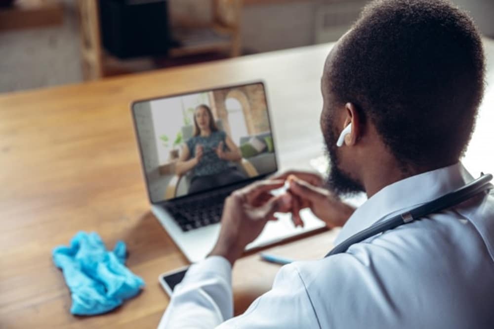 Idosa realizando consulta médica por vídeo chamada pela notebook.
