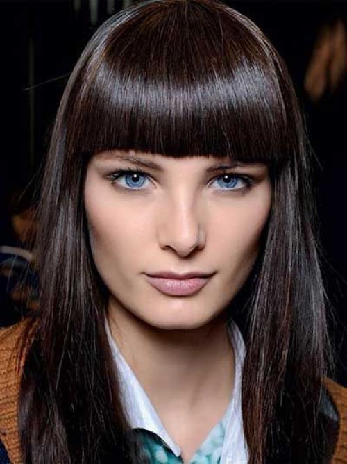 Mulher com cabelo liso e franja reta na altura da sobrancelha