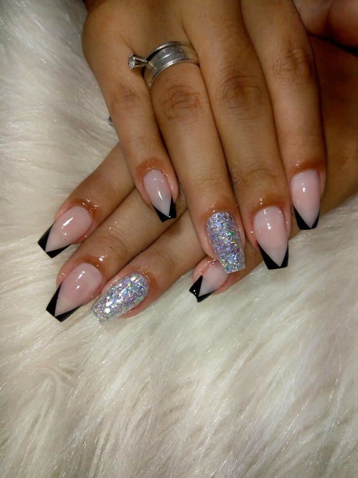 Unhas em gel encapsuladas com glitter prateado e decoração em preto nas pontas, tendência moderna para mulheres acima de 50 anos