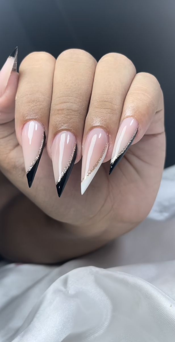 Unhas em gel no formato stiletto decoradas com preto, branco e glitter, tendência moderna para mulheres acima de 50 anos