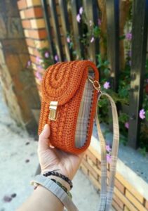 Bolsinha de crochê laranja feita à mão, com alça ajustável, perfeita para crianças.