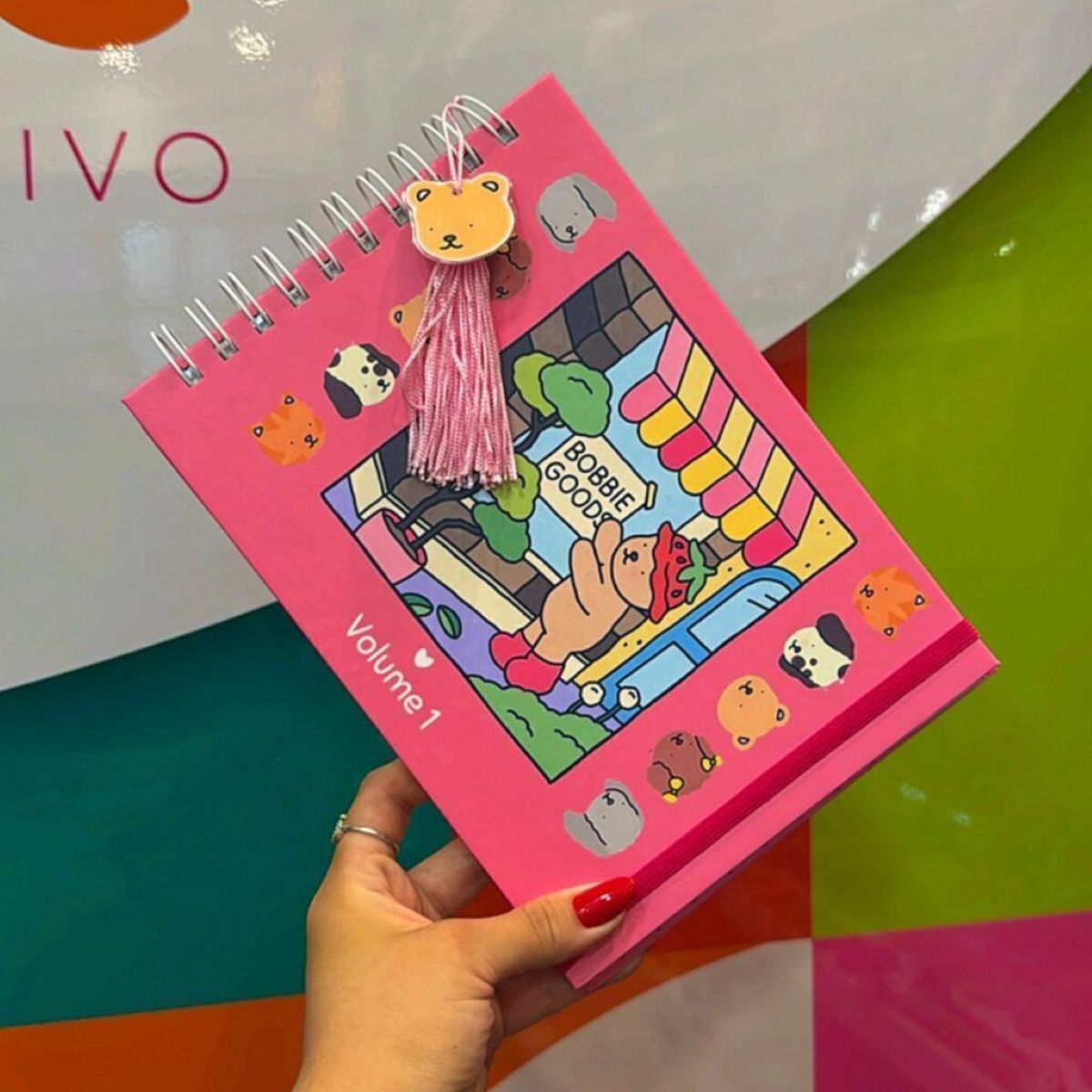 Livro de colorir Bobbie Goods Volume 1 com capa rosa, ilustração de ursinho e enfeite de pompom