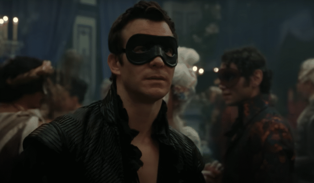 Cena de baile de máscaras com Benedict Bridgerton usando uma máscara preta na quarta temporada da série Bridgerton.