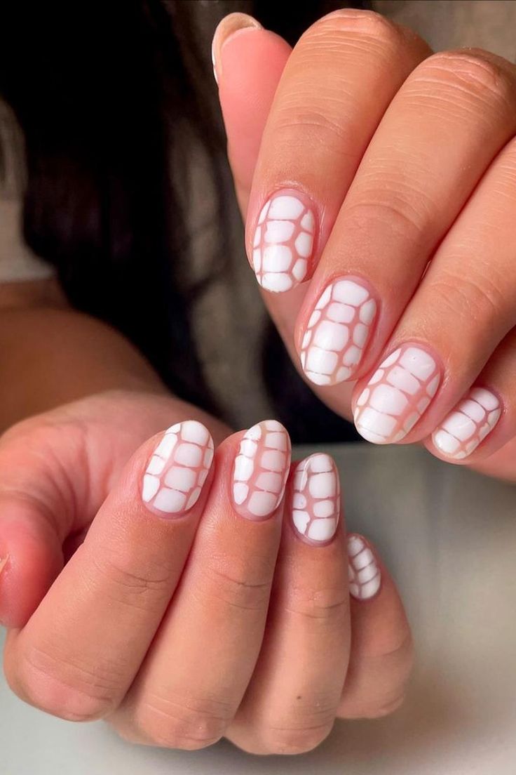 Unhas com estampa de crocodilo em fundo branco.